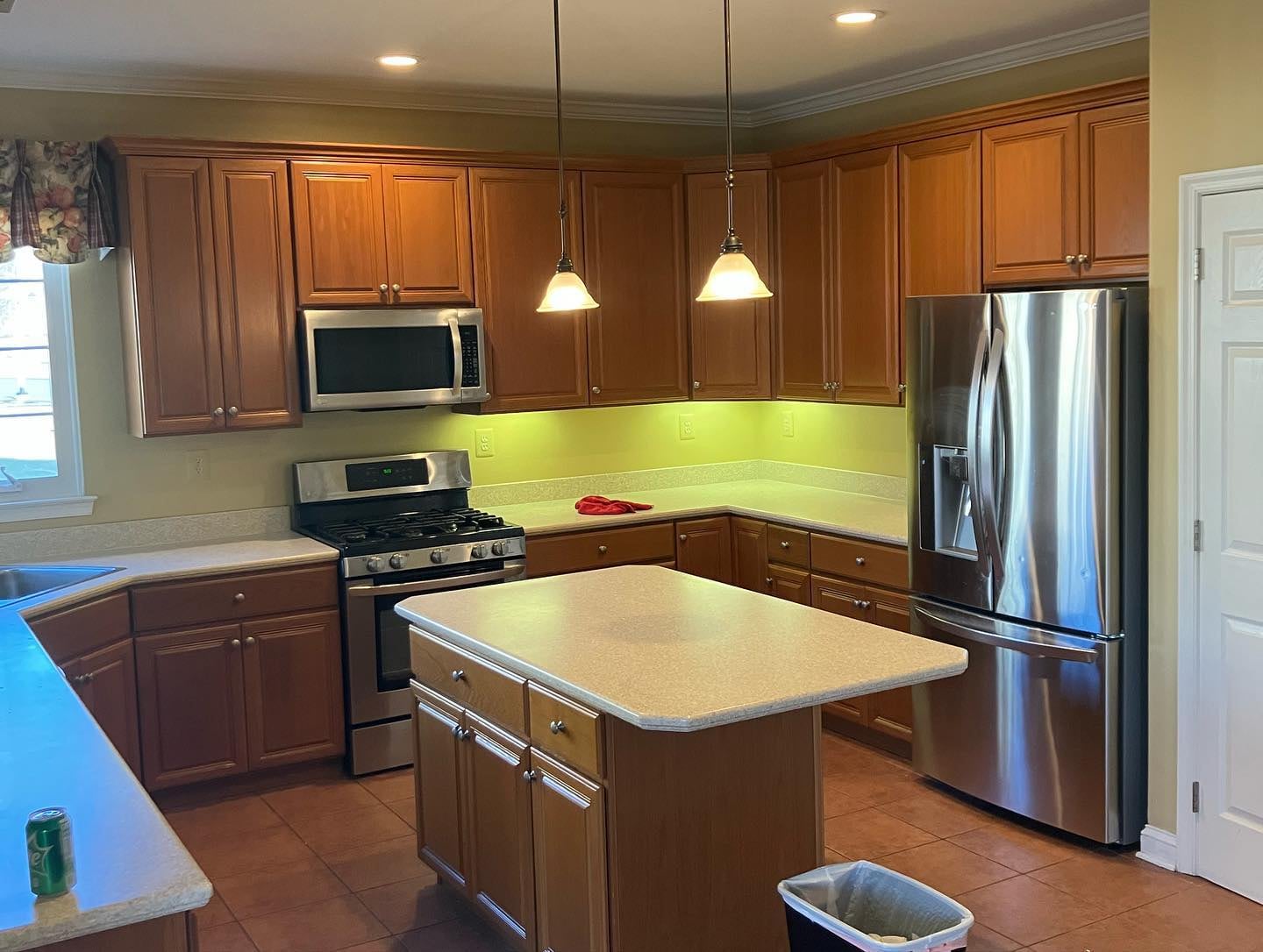 Traditional kitchen before renovation with wood cabinets and tile flooring